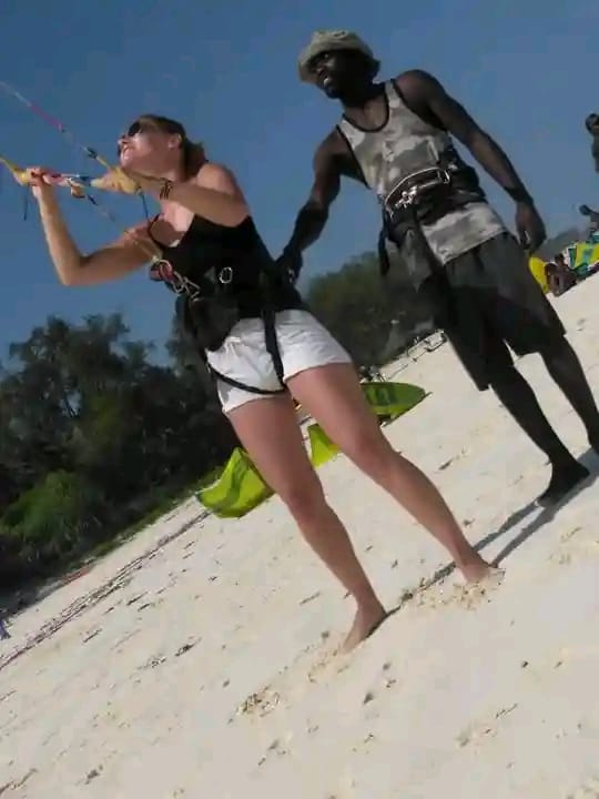 Instructor coaching a student through her first kite control on the beach