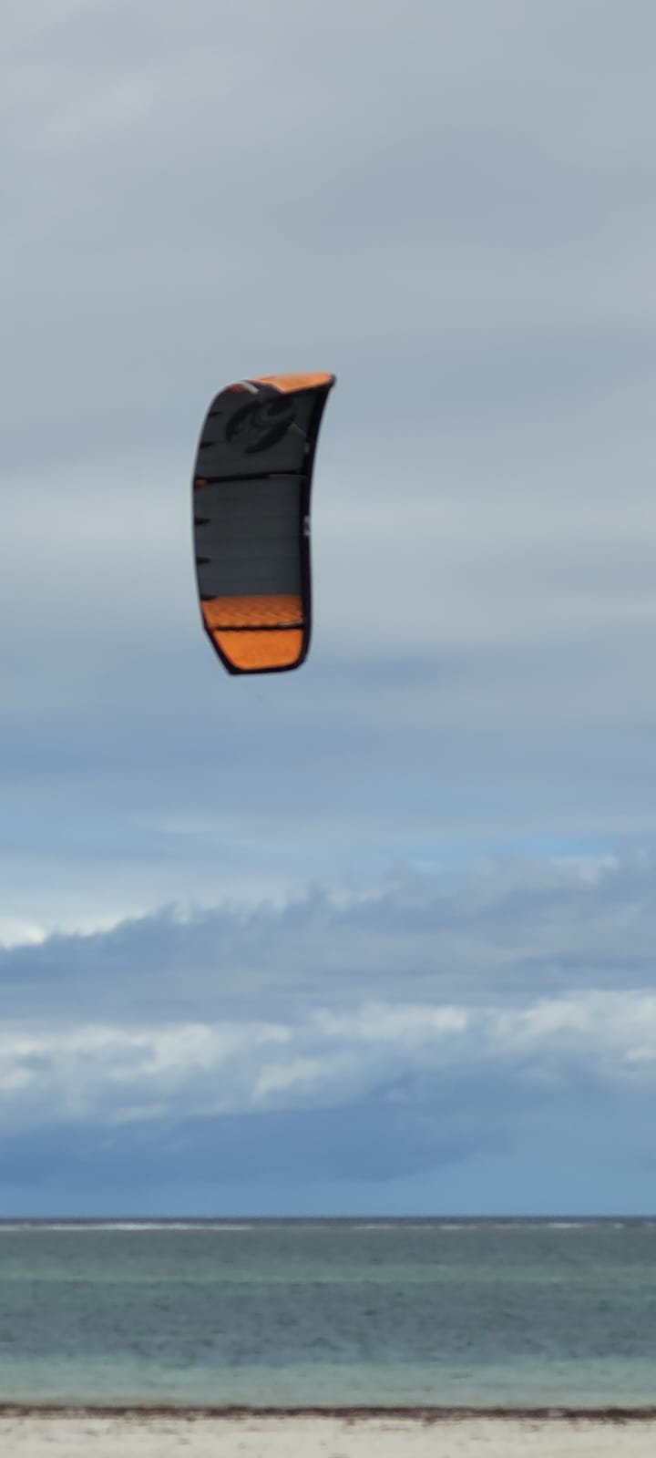 Kite in the sky over the empty reef flats on an overcast Diani day